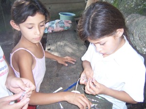 Girls in Nicaragua making beads out of old magazines.