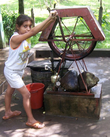 Girl getting water from a well